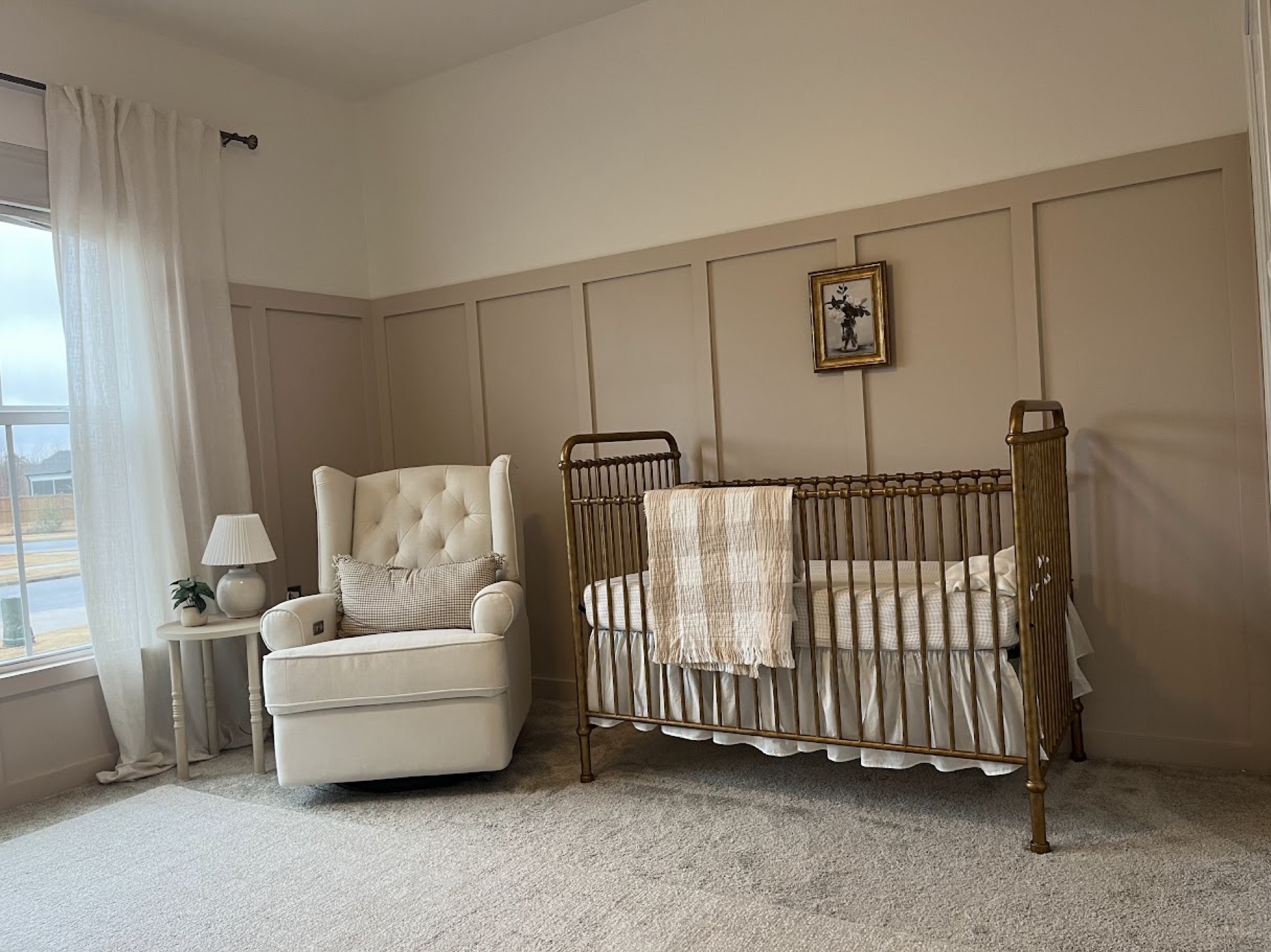 Board-and-batten accent wall and soft neutral walls for a nursery.
